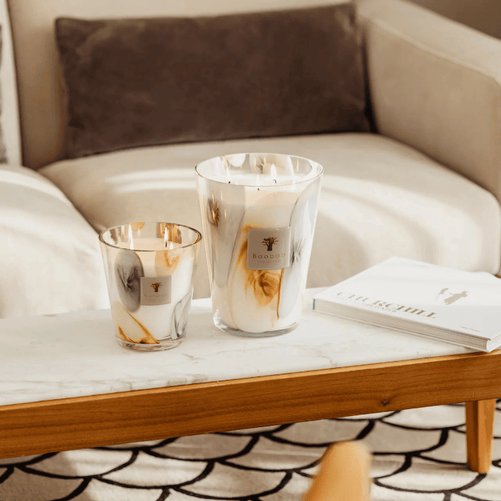 Bougies parfumées Baobab Collection en verre marbré blanc, gris et doré, posées sur une table basse en marbre dans un salon moderne – décoration élégante chez Bob Corner, concept store français