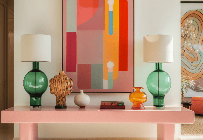 Console design rose avec lampes en verre vert, objets déco contemporains et tableau abstrait coloré – ambiance moderne Bob Corner